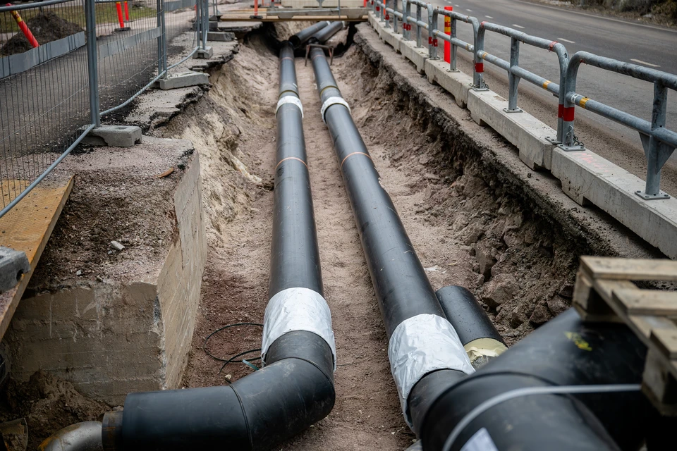 Chantier de construction ext&eacute;rieur avec ouvrier en &eacute;quipement de s&eacute;curit&eacute; travaillant au sol