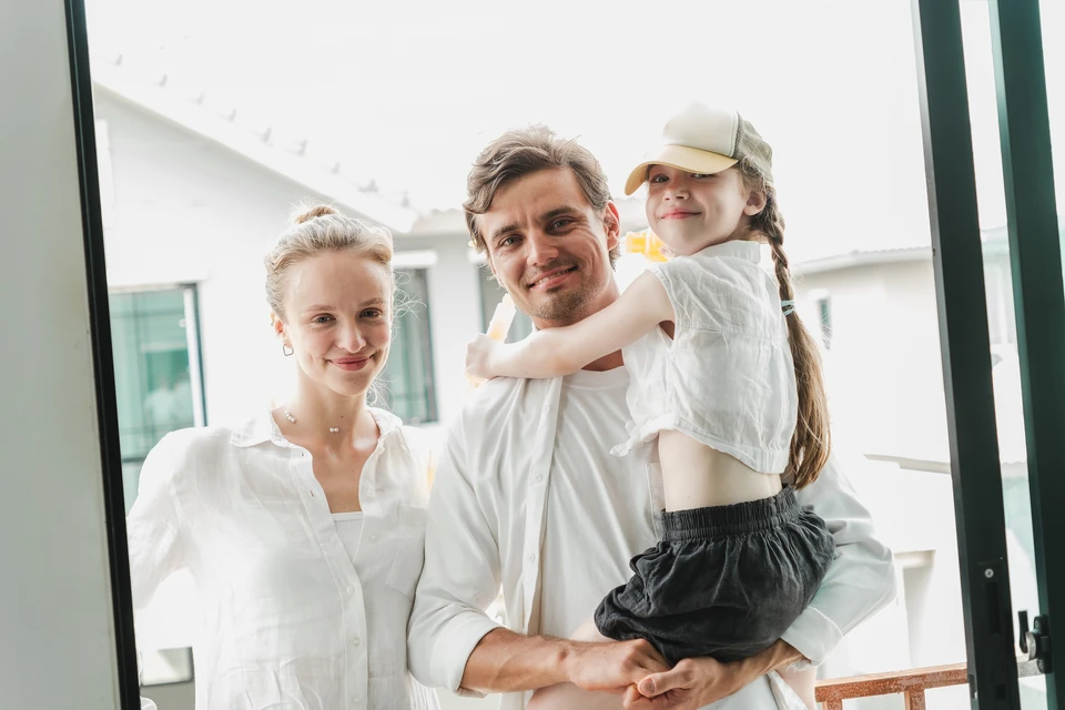 Groupe de cinq personnes en t-shirts jaunes réunies en extérieur autour d'un plan ou document déplié au sol, analysant et planifiant ensemble
